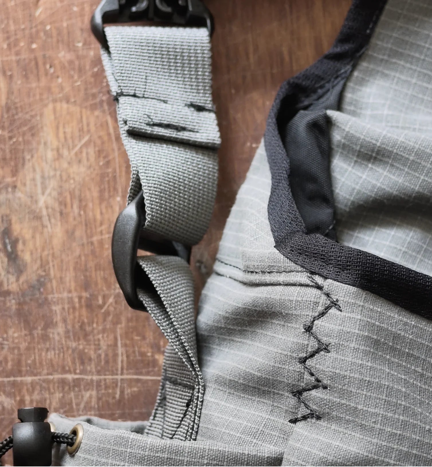 Black zigzag stitching and binding against grey ripstop fabric